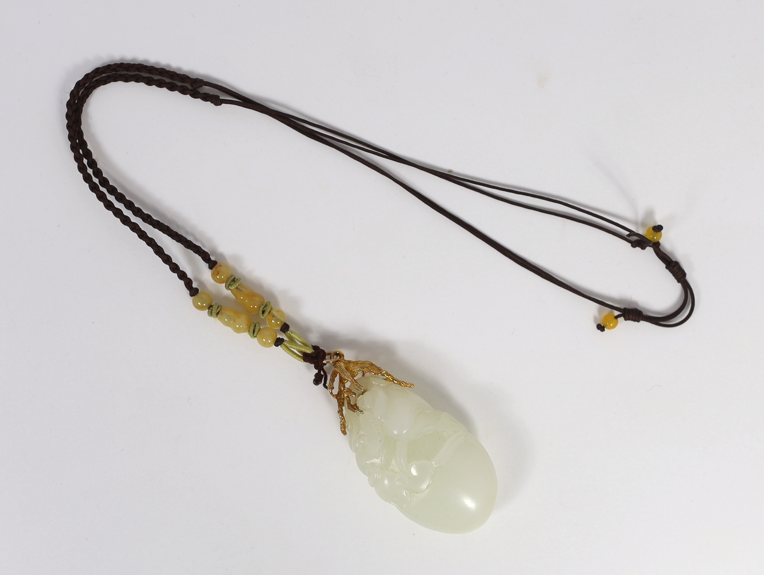 A Chinese white jade ‘conch shell’ yellow metal mounted pendant